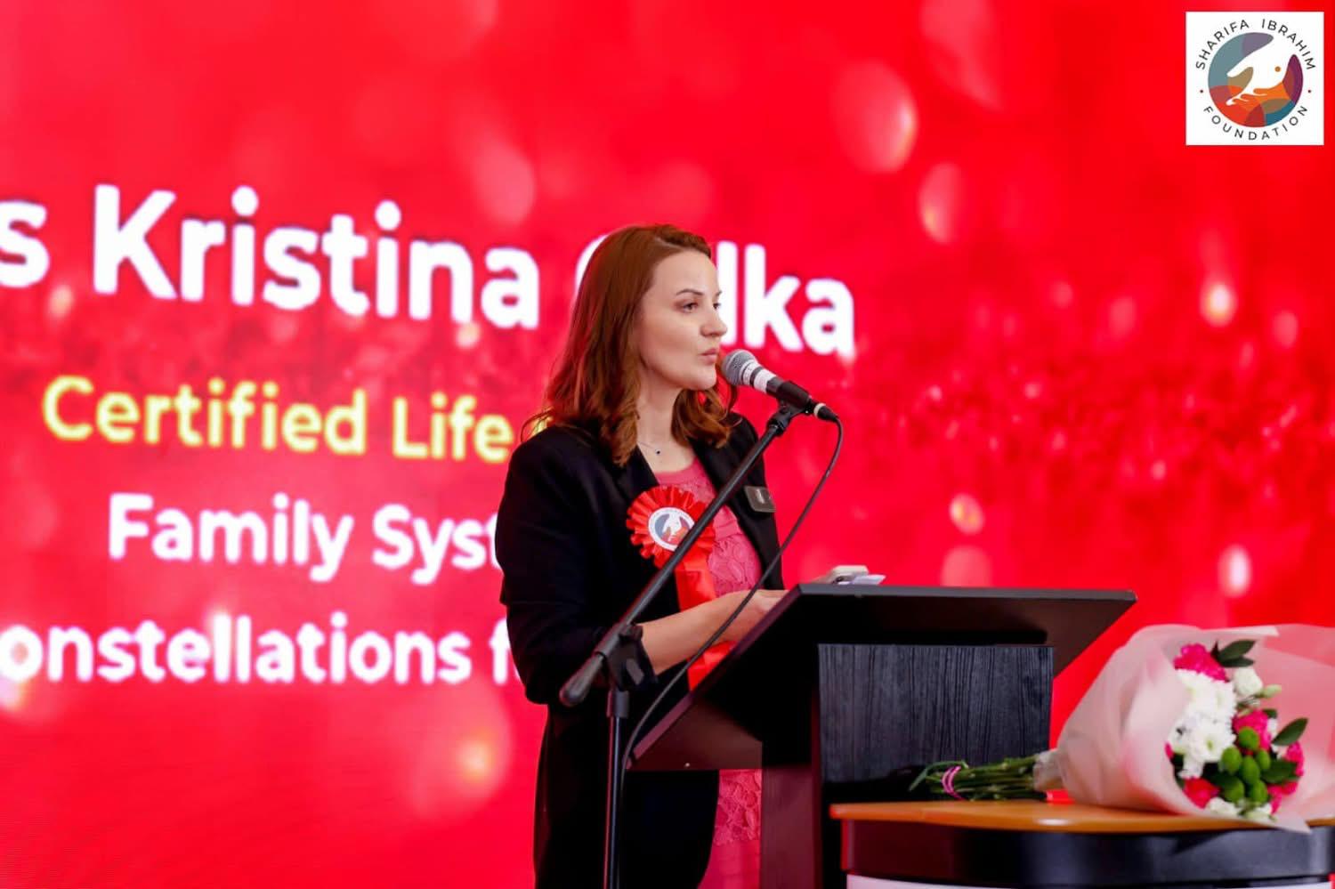 Kristina Culka speaking on stage as a certified life coach and systemic constellations facilitator