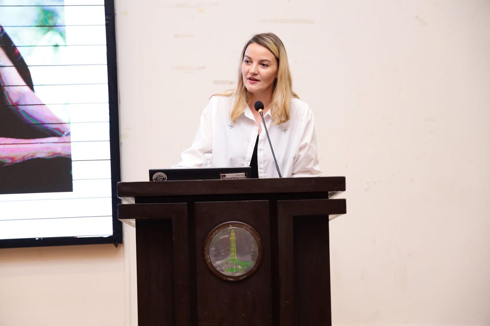 Kristina Culka speaking from a podium during a charity conference